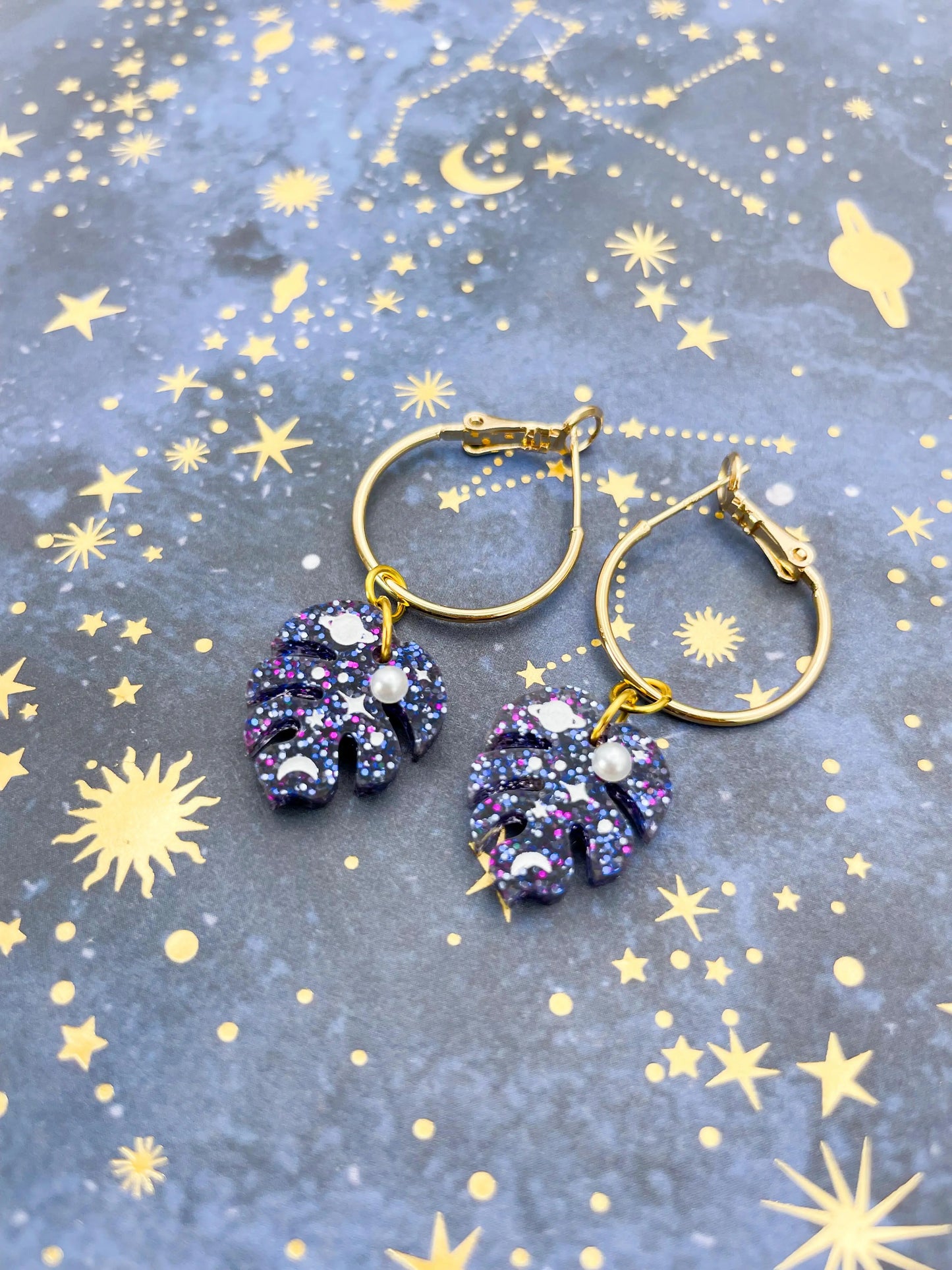 Small Purple and Blue Glitter Planet and Pearl Acrylic Monstera Leaf Hoops from Sapphire Frills