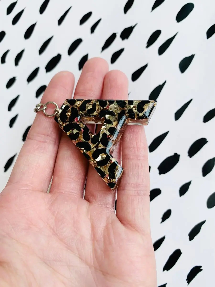 https://www.sapphirefrills.com/cdn/shop/products/Gold-Glitter-Leopard-Print-Initial-Keyring-from-Sapphire-Frills-1661979038.jpg?v=1661979040&width=1445